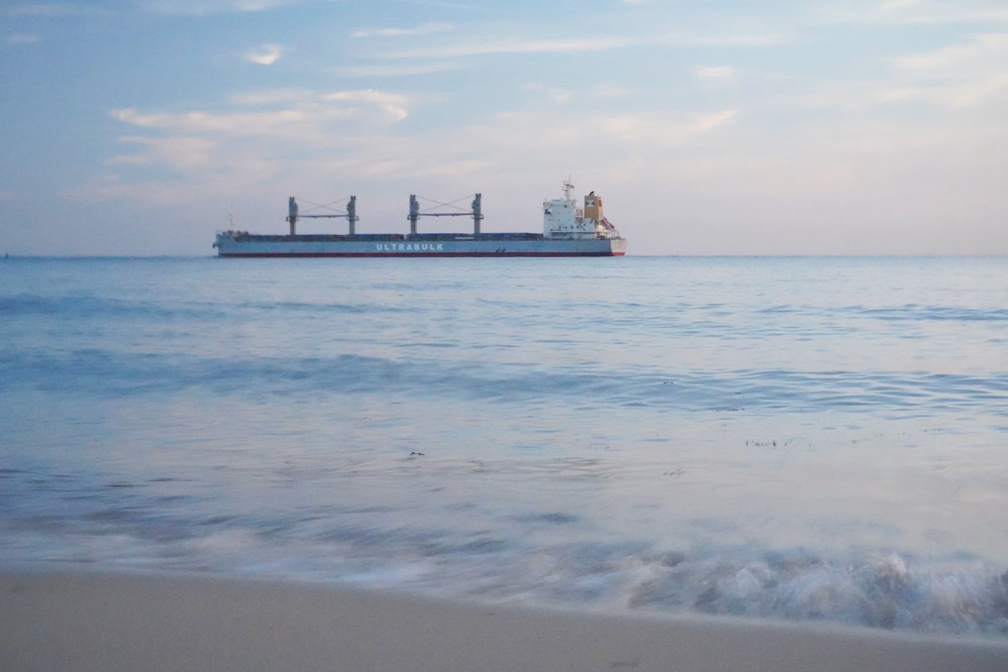 Cargo ship on the horizon, calm sea
