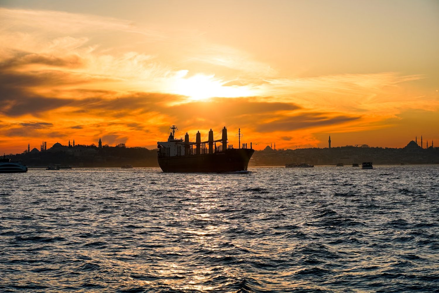 Cargo ship silhouetted at sunset